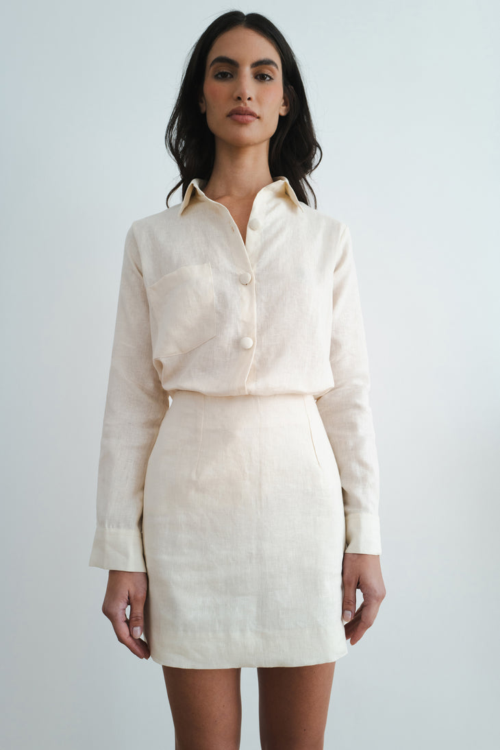 Woman wearing cream linen button-up shirt and matching mini skirt set against white background — Amara Grace | Endless UAE
