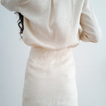Rear view of woman wearing cream linen Cassidy Set showing relaxed blazer and matching mini skirt — Amara Grace | Endless UAE