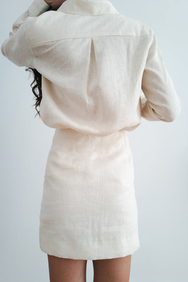 Rear view of woman wearing cream linen Cassidy Set showing relaxed blazer and matching mini skirt — Amara Grace | Endless UAE