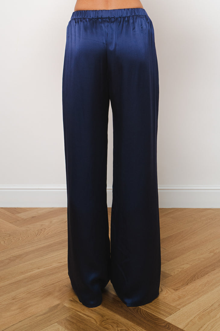 Navy blue silk wide-leg trousers with elastic waistband, rear view on model — Amara Grace | Endless UAE