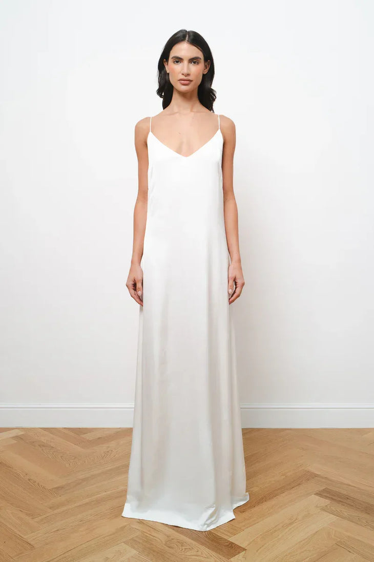 Elegant white maxi dress with thin spaghetti straps and V-neckline in flowing silhouette — Amara Grace | Endless UAE