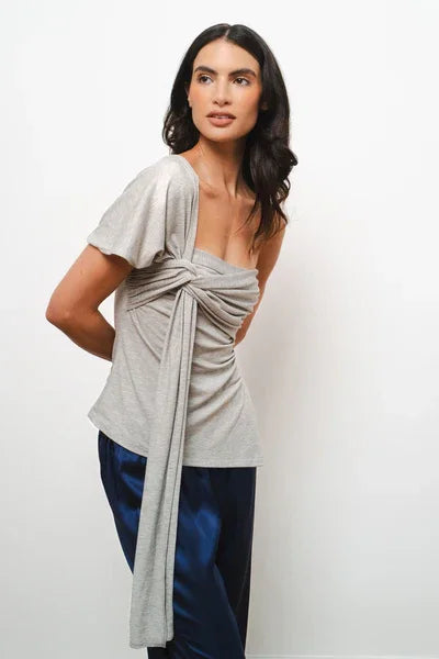 Gray wrap top with tie detail and flutter sleeves styled with navy pants — Amara Grace | Endless UAE