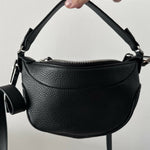 Black leather mini shoulder bag with textured finish held open to show interior — By Far | Endless UAE