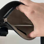 Black leather mini shoulder bag with textured finish held open to show interior — By Far | Endless UAE
