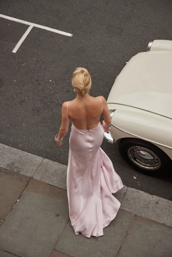 Elegant pink satin backless maxi dress with cowl back and flowing skirt, styled with vintage car — By Keara | Endless UAE