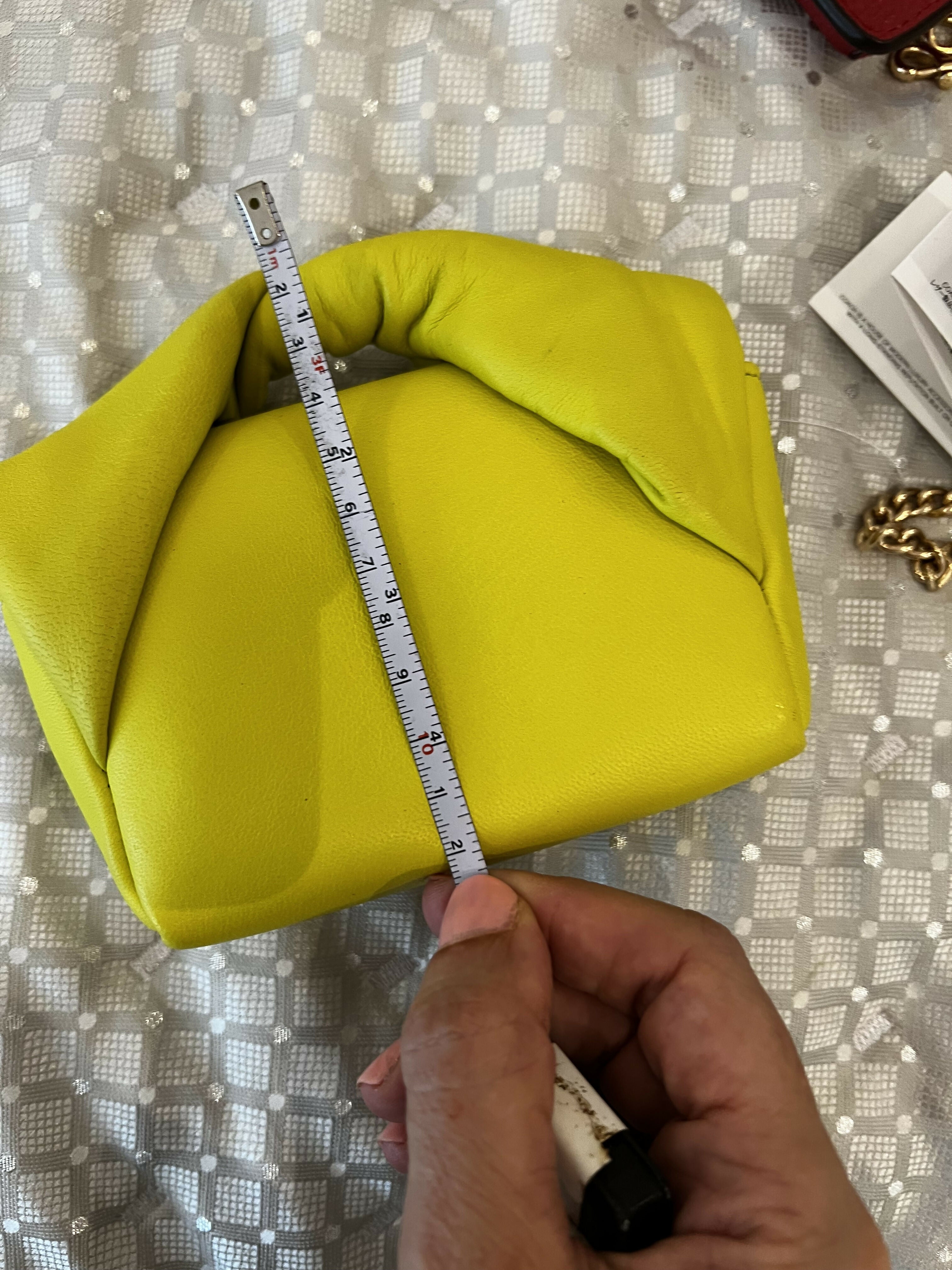 Hand measuring lime yellow padded leather Twister Nano crossbody bag with tape measure — JW Anderson | Endless UAE