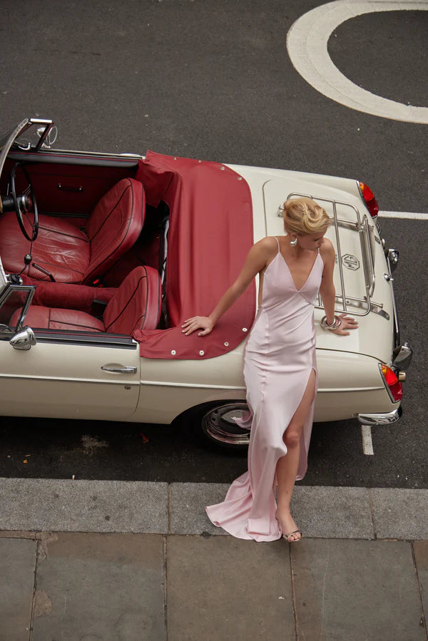 Elegant pink backless maxi dress with high slit and halter neckline styled with vintage convertible car — By Keara | Endless UAE