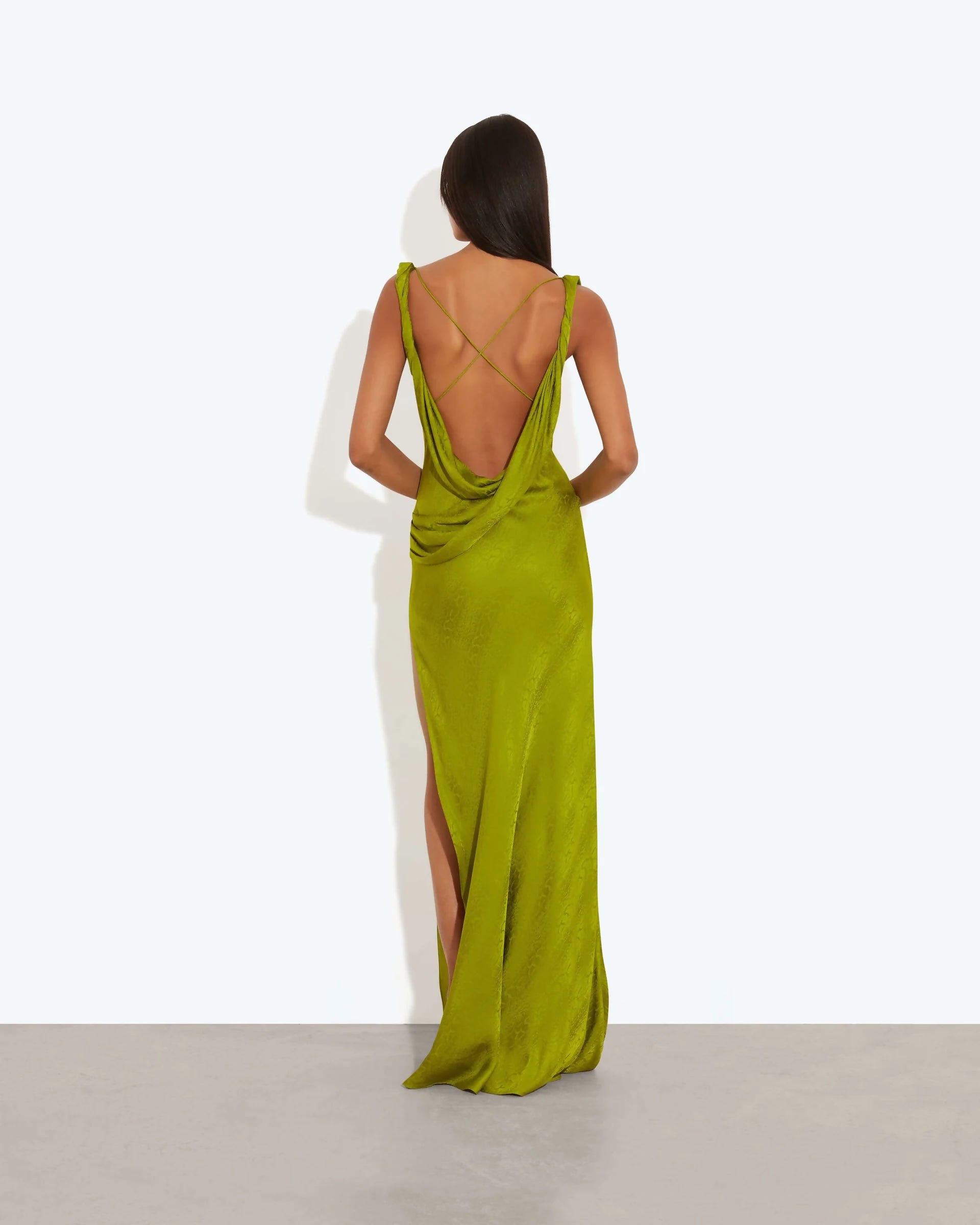 Lime green floor-length dress with open draped back, crossed straps, and side slit, modeled from behind — Rat and Boa | Endless UAE