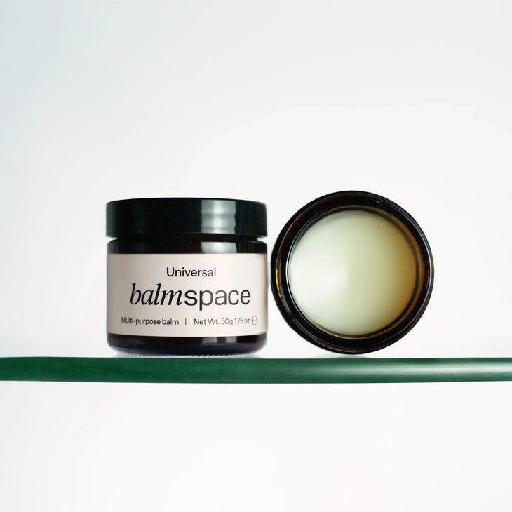 Multi-purpose balm jar with black lid and cream-colored balm, shown open on green shelf — Balm Space | Endless UAE