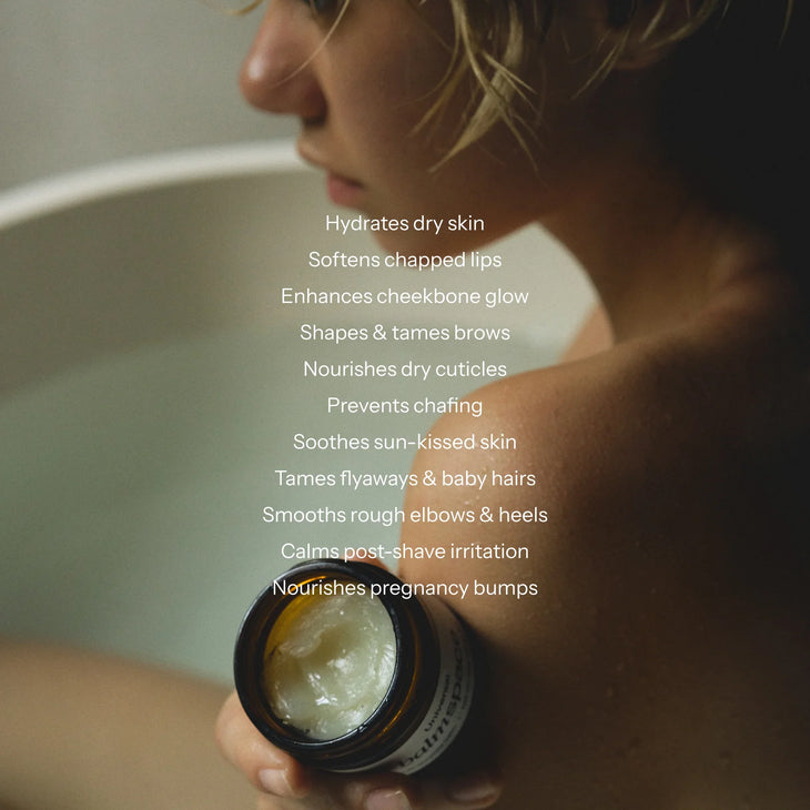 Woman holding open jar of multi-purpose balm with list of benefits including hydrates skin, softens lips, and nourishes cuticles — Balm Space | Endless UAE