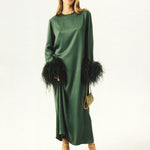 Woman wearing forest green satin midi dress with black feather cuffs and gold sandals — Sleeper | Endless UAE