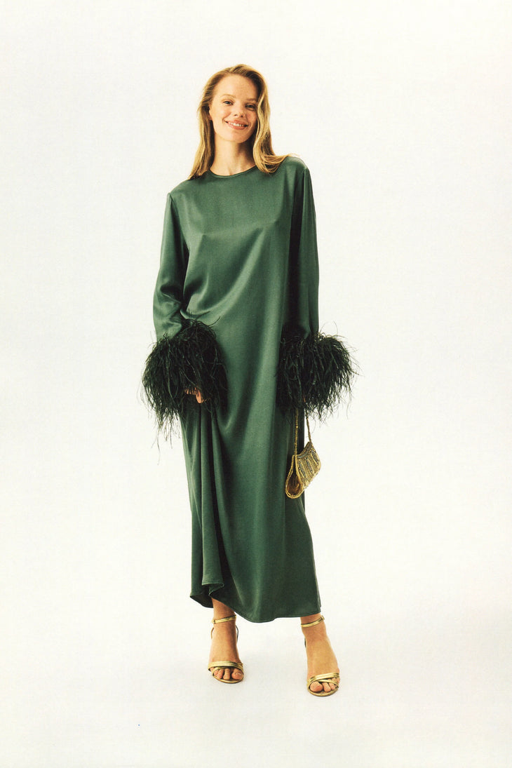 Woman wearing forest green satin midi dress with black feather cuffs and gold sandals — Sleeper | Endless UAE