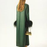 Woman wearing forest green satin midi dress with black feather cuffs and gold sandals — Sleeper | Endless UAE