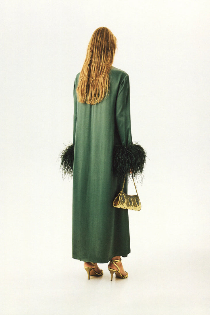 Woman wearing forest green satin midi dress with black feather cuffs and gold sandals — Sleeper | Endless UAE