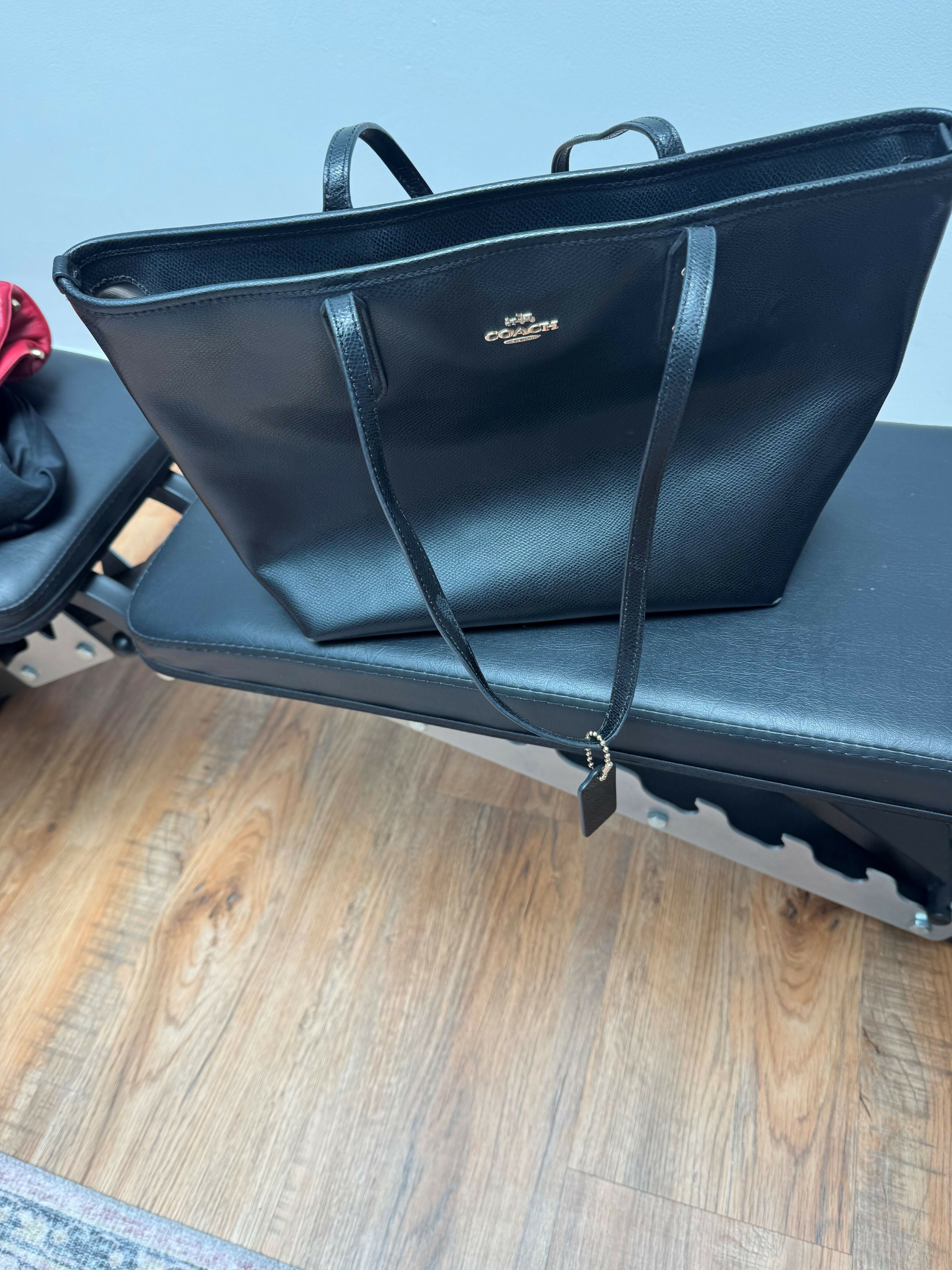 Black leather tote bag with dual handles and Coach branding — Coach | Endless UAE