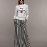 Model wearing Chanel Cruise 2019 striped wide leg trousers with white sweatshirt — Chanel | Endless UAE