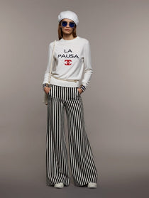 Model wearing Chanel Cruise 2019 striped wide leg trousers with white sweatshirt — Chanel | Endless UAE
