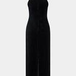 Woman wearing black halter neck velvet evening dress standing in front of historic building — COPURS | Endless UAE