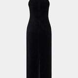 Woman wearing black halter neck velvet evening dress standing in front of historic building — COPURS | Endless UAE