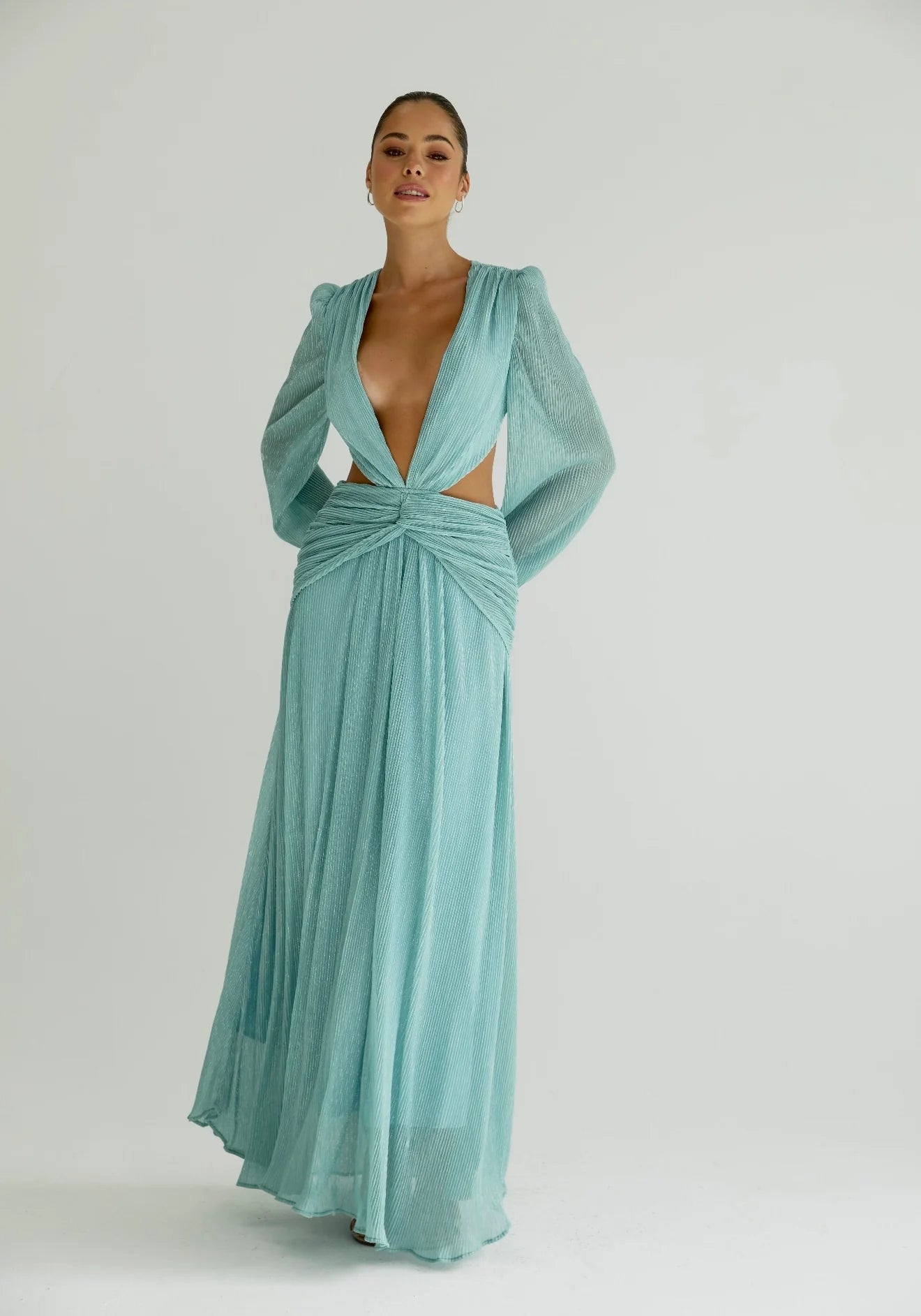Woman wearing a flowing light blue wrap dress with long sleeves and cutout waist detail — Anne Louise Boutique | Endless UAE