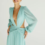 Woman wearing a flowing light blue wrap dress with long sleeves and cutout waist detail — Anne Louise Boutique | Endless UAE