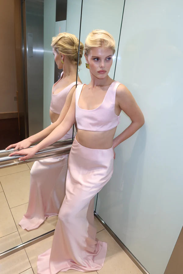 Elegant pink satin maxi skirt with matching crop top, worn by blonde model in modern interior — By Keara | Endless UAE