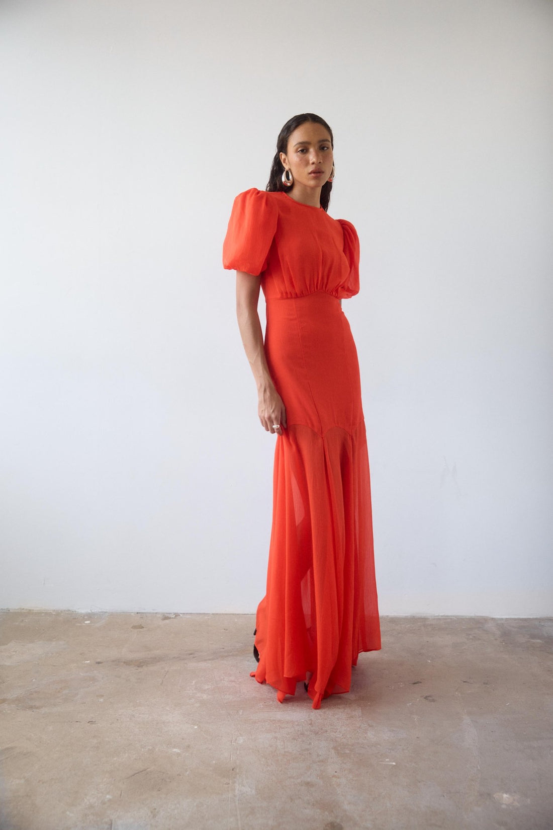 Woman wearing red crinkle chiffon maxi dress with puff sleeves — De La Vali | Endless UAE