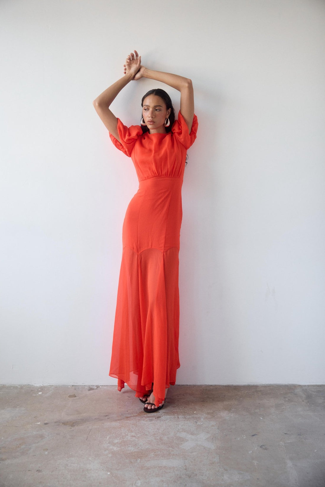 Woman wearing red crinkle chiffon maxi dress with puff sleeves — De La Vali | Endless UAE
