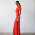 Woman wearing red crinkle chiffon maxi dress with puff sleeves — De La Vali | Endless UAE