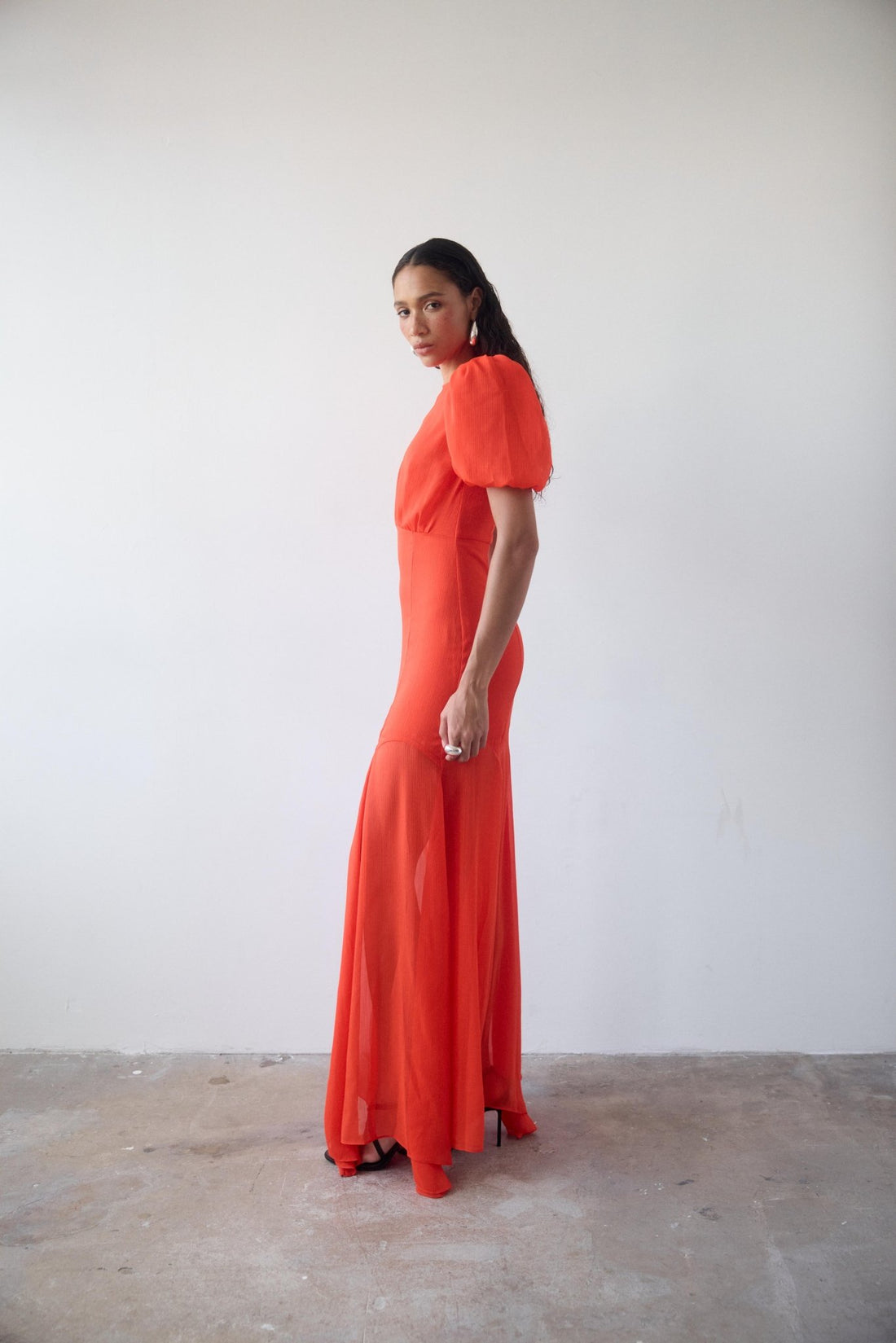 Woman wearing red crinkle chiffon maxi dress with puff sleeves — De La Vali | Endless UAE