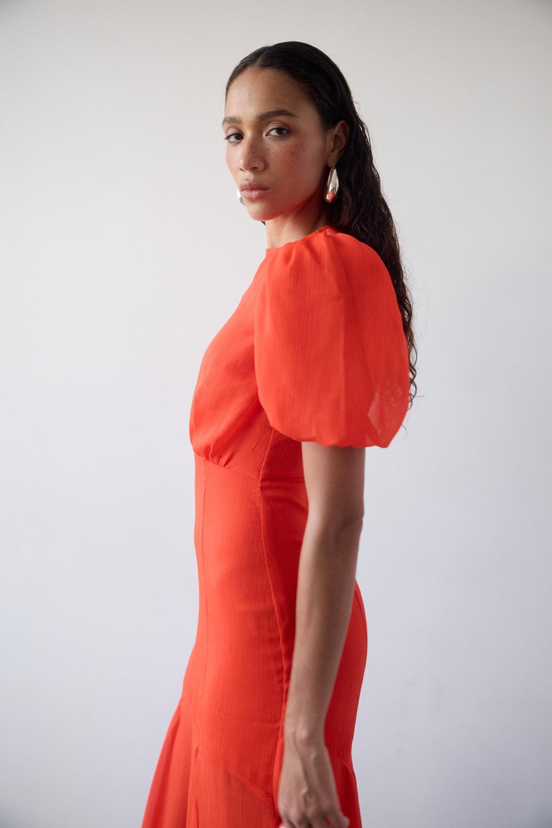 Woman wearing red crinkle chiffon maxi dress with puff sleeves — De La Vali | Endless UAE