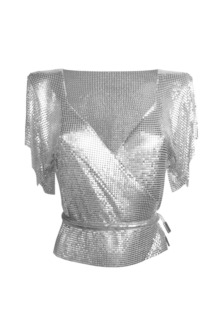 Silver sequin sleeveless wrap top styled with black shorts on rocky terrain — Isabel Moore | Endless UAE