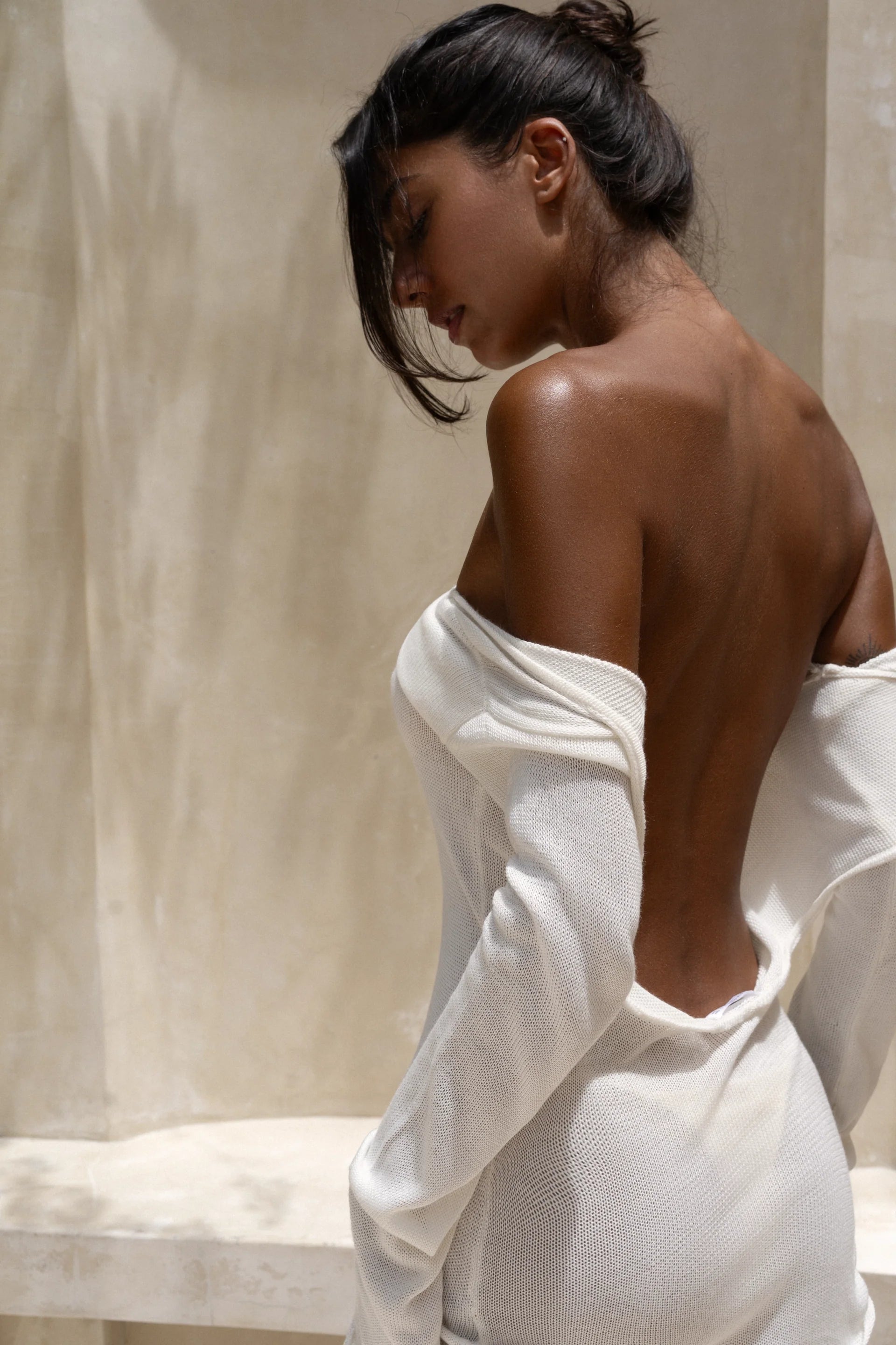 Strapless white tunic draped elegantly on model in sunlit architectural setting — Nuverance | Endless UAE