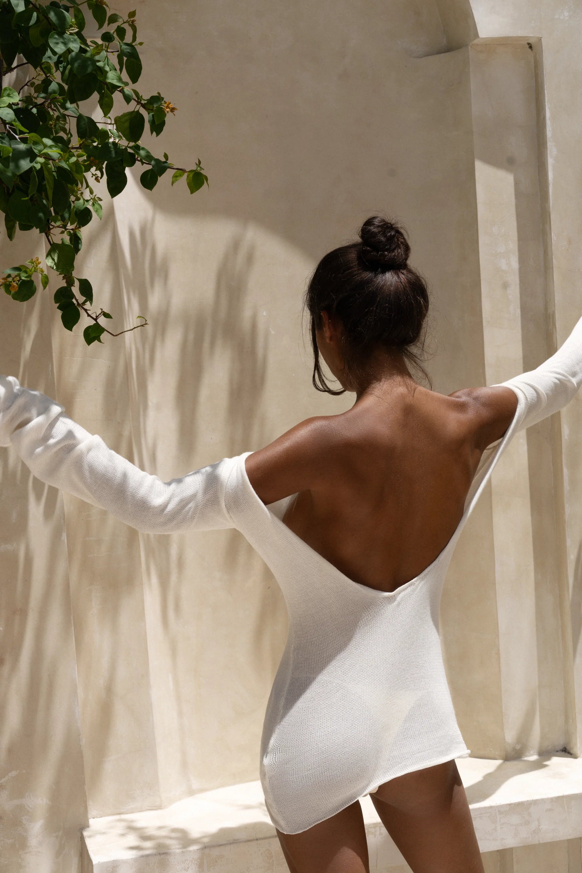 Strapless white tunic draped elegantly on model in sunlit architectural setting — Nuverance | Endless UAE