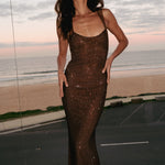 Jasmyn Hot Fix Maxi Dress With Mesh Back in bronze worn by woman against beach backdrop — Meshki | Endless UAE