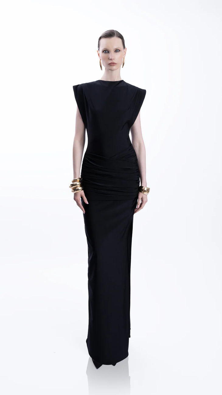 Woman wearing black sleeveless maxi dress with ruched side detail and gold bangles — Lediel | Endless UAE