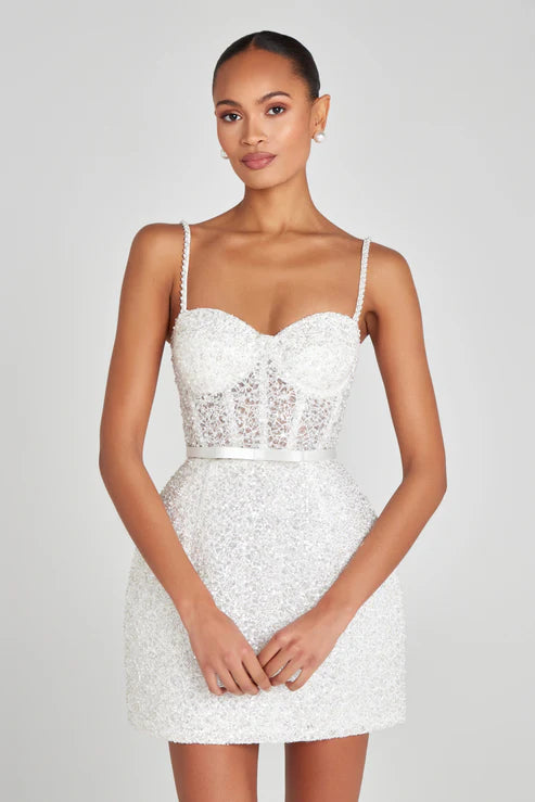 Elegant white mini dress with pearl embellishments, corset bodice, and sheer lace panel detail — Nadine Merabi | Endless UAE