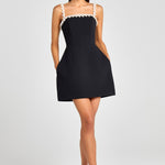 Woman wearing black sleeveless dress with white pearl neckline and straps — Nadine Merabi | Endless UAE