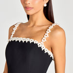 Woman wearing black sleeveless dress with white pearl neckline and straps — Nadine Merabi | Endless UAE