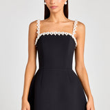 Woman wearing black sleeveless dress with white pearl neckline and straps — Nadine Merabi | Endless UAE