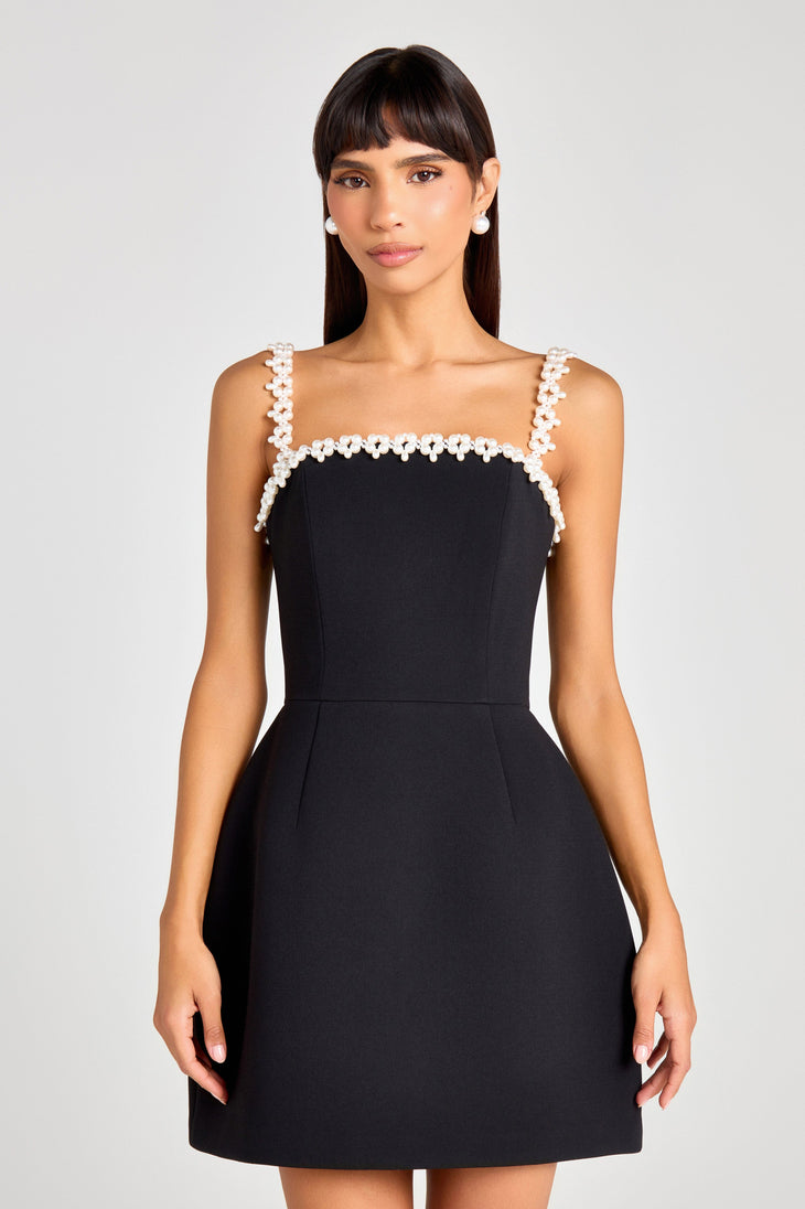 Woman wearing black sleeveless dress with white pearl neckline and straps — Nadine Merabi | Endless UAE