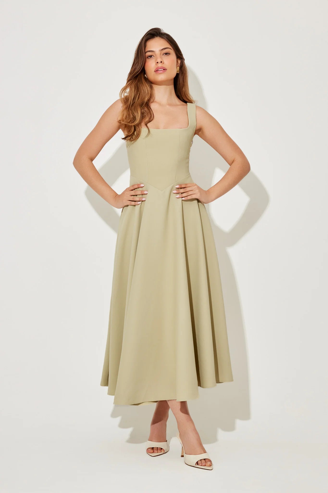 Woman wearing sage green square neck midi dress with pleated skirt and white slide sandals — Odd Muse | Endless UAE
