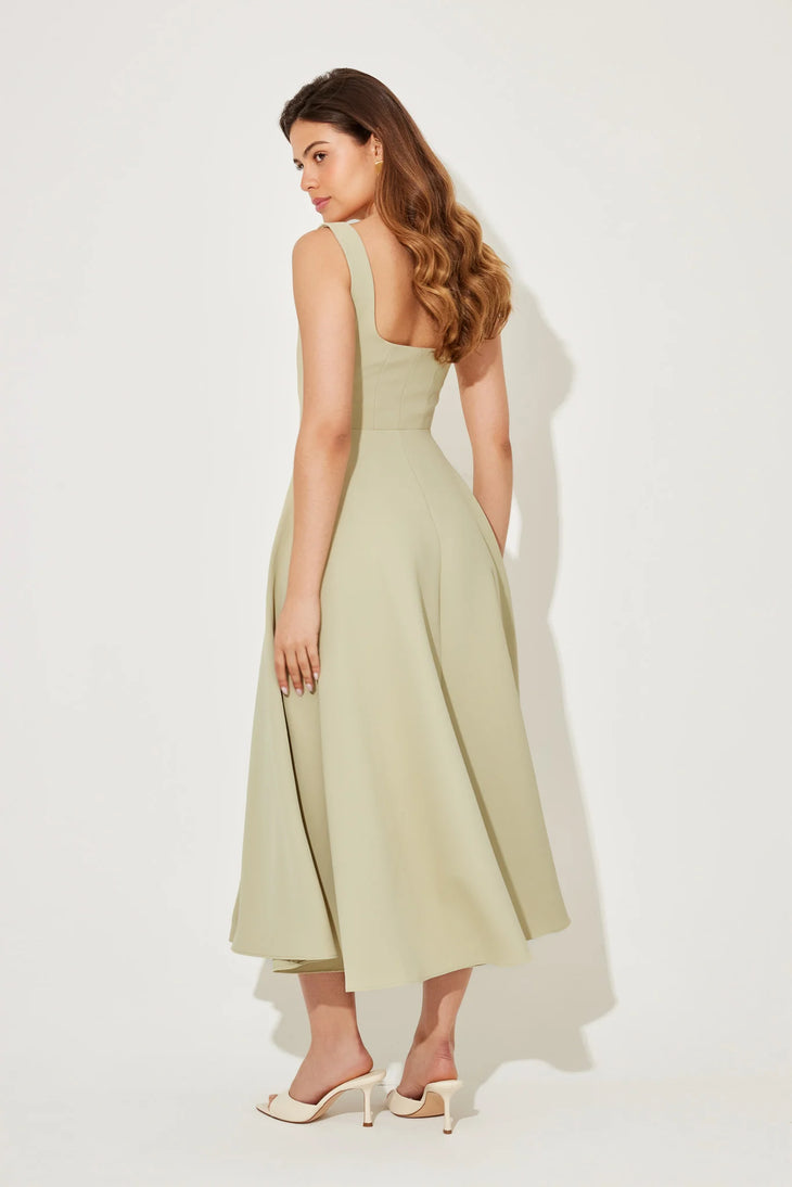 Woman wearing sage green square neck midi dress with pleated skirt and white slide sandals — Odd Muse | Endless UAE