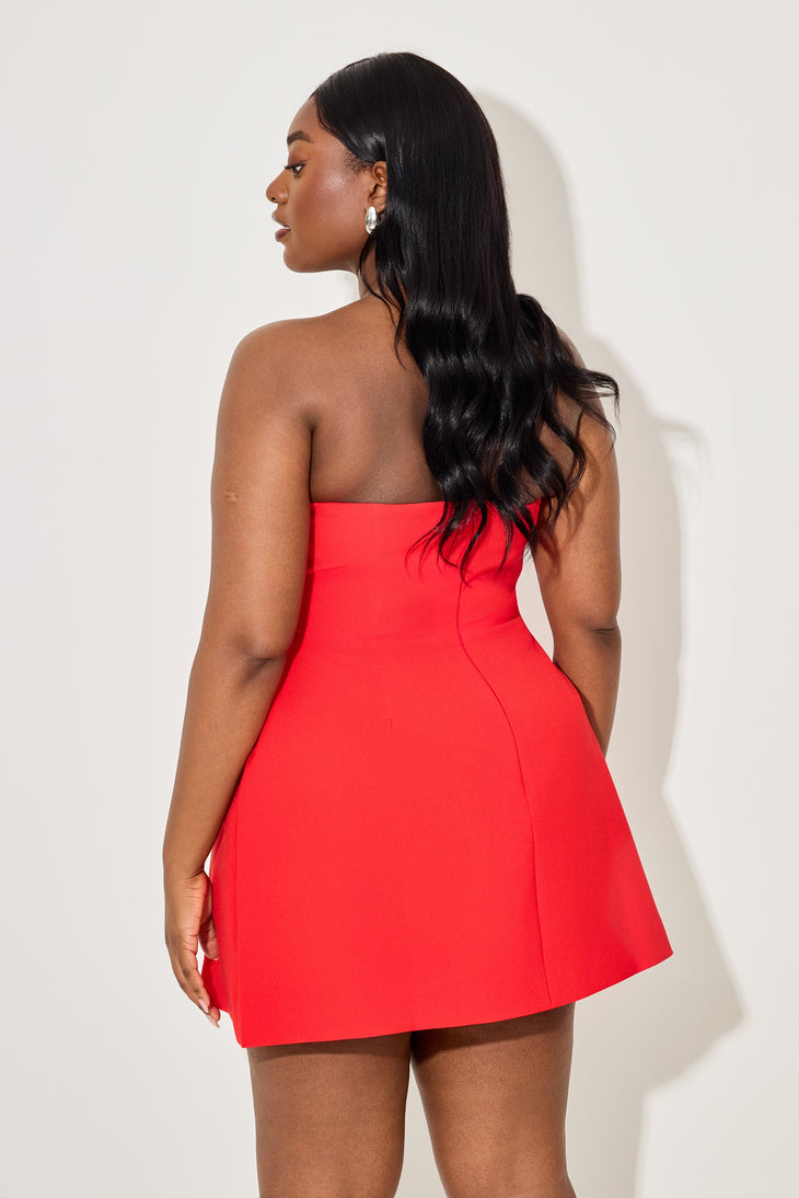 Woman wearing bright red strapless mini dress viewed from back, long dark hair, minimal styling — Odd Muse | Endless UAE