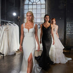 Sleek white wedding dress with plunging neckline and front slit, modeled in industrial bridal showroom — You&I Bridal | Endless UAE