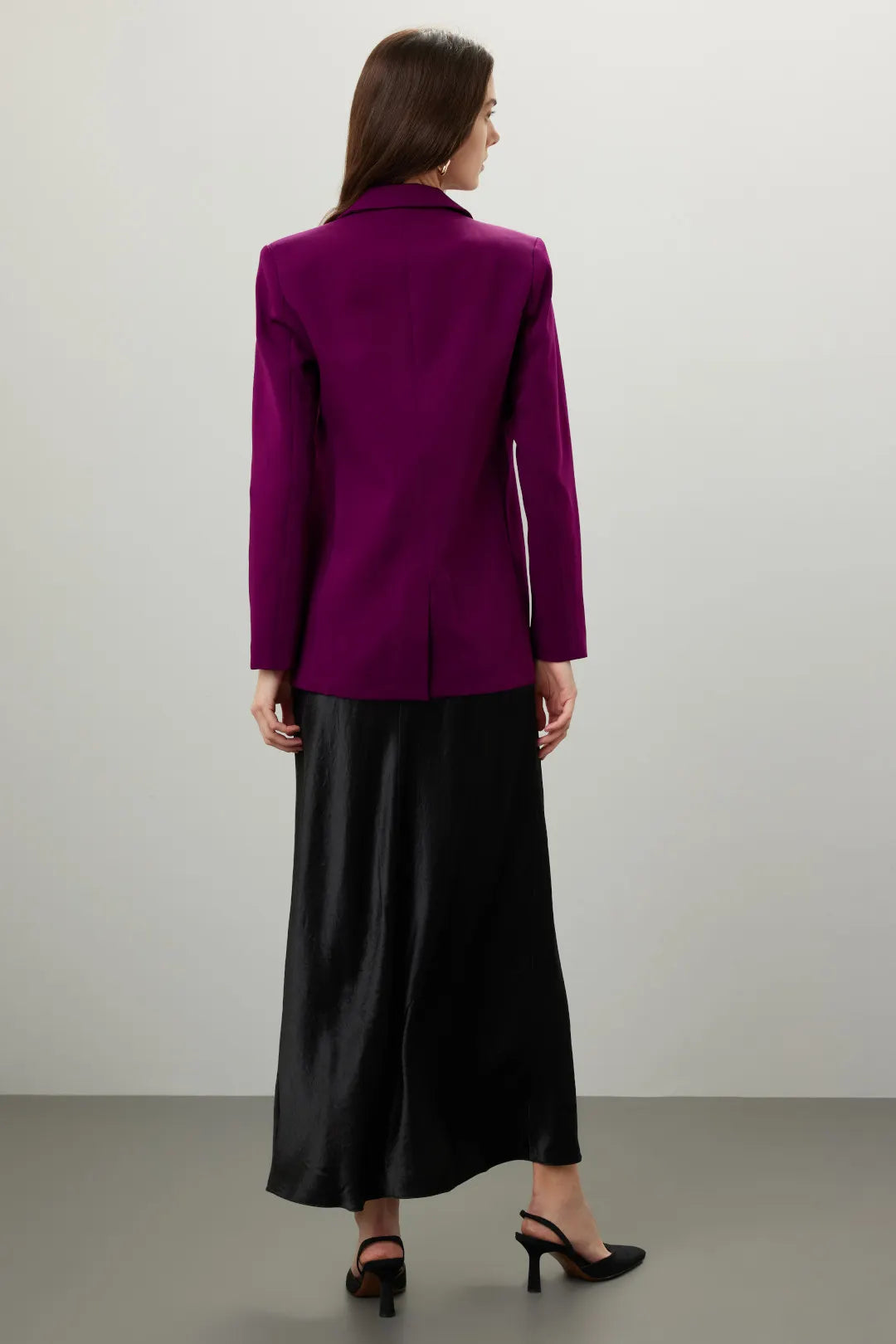 Woman wearing magenta single breasted blazer with black satin maxi skirt viewed from behind — Endless Rose | Endless UAE