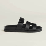 Black leather slip-on sandal with crossover straps and buckle fastening on chunky treaded sole — Hermes | Endless UAE