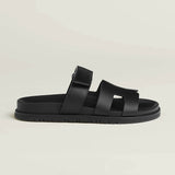 Black leather slip-on sandal with crossover straps and buckle fastening on chunky treaded sole — Hermes | Endless UAE