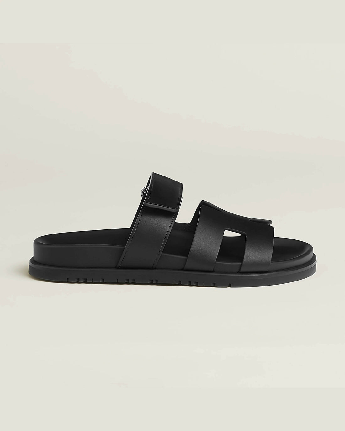 Black leather slip-on sandal with crossover straps and buckle fastening on chunky treaded sole — Hermes | Endless UAE