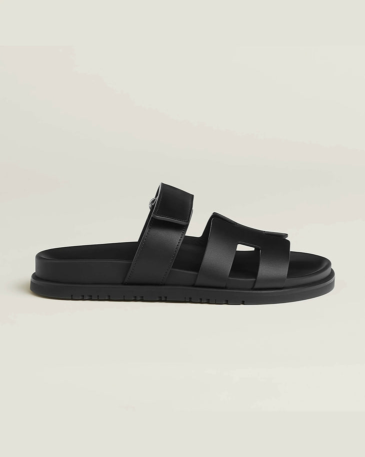 Black leather slip-on sandal with crossover straps and buckle fastening on chunky treaded sole — Hermes | Endless UAE